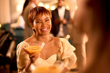 Woman At Party Talking To Guest And Drinking Cocktail