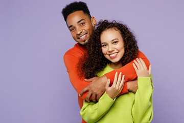 Young happy fun lovely couple two friends family man woman of African American ethnicity wearing casual clothes together husband hugging smiling wife isolated on pastel plain light purple background.