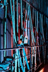 Cable and chain rigging backstage in a theater. Vertical lines. Neon blue and red color