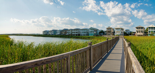 Boardwalk with wooden railings over the tall grasses in a lake near the residences at Destin, FL