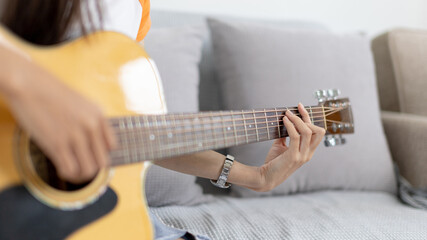 Close up fingers playing guitar strings, Strum to make a sound, Acoustic guitar, Catching guitar chords to create music, Music therapy and meditation practice with playing the guitar.