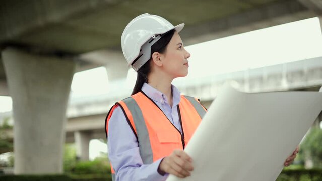 Supervisor woman Engineer or architect Using blueprint for checking and maintenance to inspection in construction site. Engineer female working at construction project. Civil engineering concept.