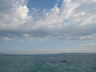 Obraz premium Positive backdrop in pastel colors. Beautiful sea and sky background. Beach and seagulls on the sea. Scenic seascape near resort town. People like rest time outdoors.