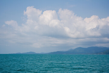 Island moiuntain hills silhouette under fluffy clouds