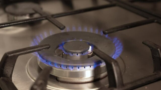 Close shot of a gas burner igniting on a stove hob. Gas ring being turned on on gas hob, as energy prices continue to rise during the cost of living crisis in Europe and in other countries.