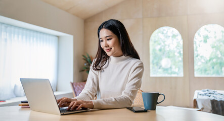 Portrait of nerd sme business asian woman work from home at online computer desktop table. Beauty Asia freelancer girl using laptop in bed room. Small business sme digital network, technology.