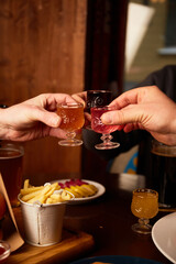 Man and woman drink different liquors in pub. Friends having alcoholic drinks in the bar
