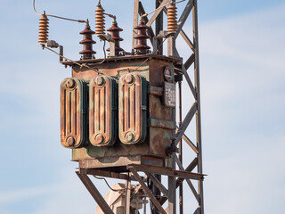 Viejo transformador de distribución colgado en una torre electrica