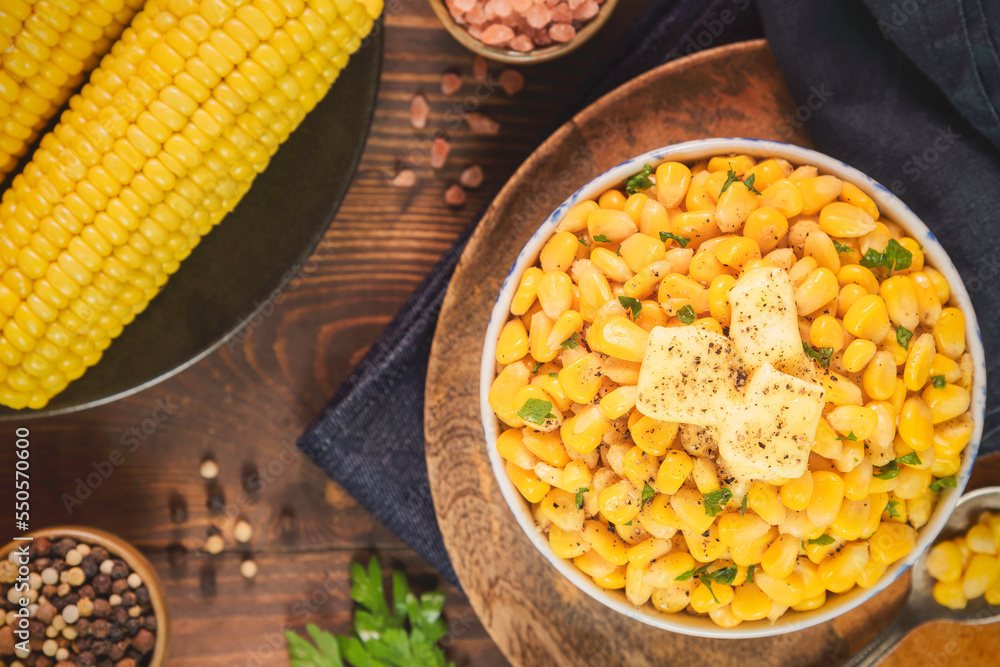 Wall mural sweet corn kernels in small bowl. topped with delicious melted butter. served with fresh corn on cob