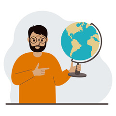 A man holds a globe in his hand and points his finger at it. The concept of education, teacher, world conquest, ecology.