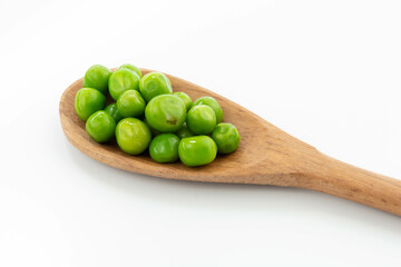 green peas isolated. fresh organic vegetables. on a wooden spoon