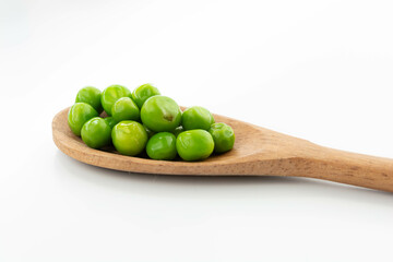 green peas isolated. fresh organic vegetables. on a wooden spoon
