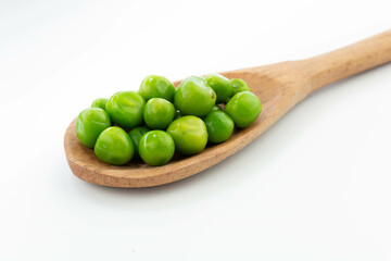 green peas isolated. fresh organic vegetables. on a wooden spoon