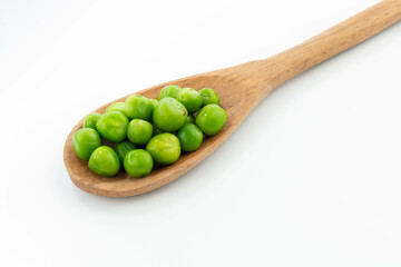 green peas isolated. fresh organic vegetables. on a wooden spoon