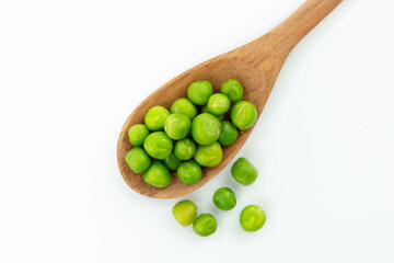 green peas isolated. fresh organic vegetables. on a wooden spoon. top view