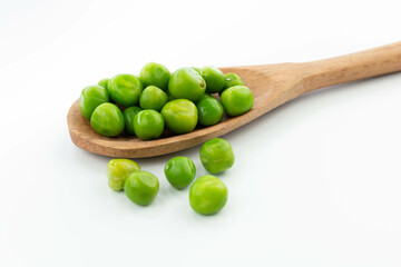 green peas isolated. fresh organic vegetables. on a wooden spoon