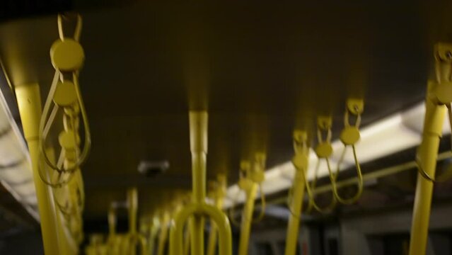 Yellows handles of the subway moving together while the empty train move on