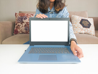 mockup laptop. asian woman showing new model laptop to recommend buying advice in casual jean jacket on white table