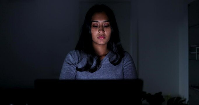 Young woman working late on laptop