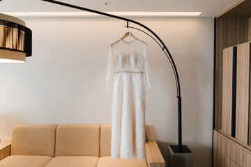White gown or wedding dress hanging as a preparation for wedding.