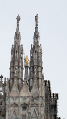 Fototapeta na wymiar Artistic and picturesque photo of a detail of the Milan Cathedral (Metropolitan Cathedral of the Nativity of the Blessed Virgin Mary) symbol of the Lombard capital surrounded by a sky full of clouds.
