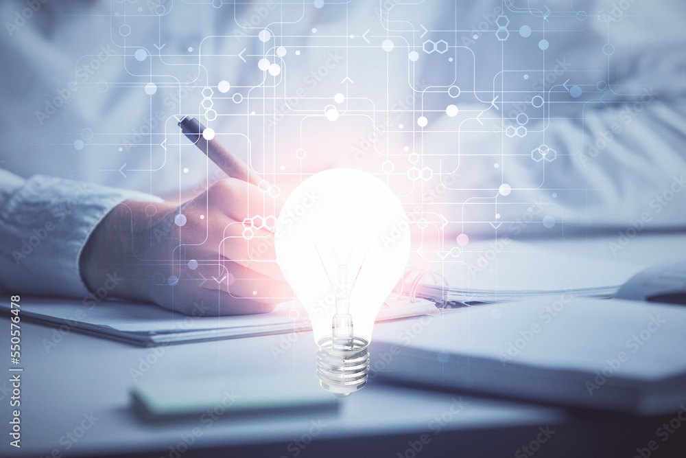 Poster bulb hologram over hands taking notes background. concept of idea. double exposure