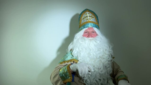 attention shows heart with hands turquoise and gold suit long white beard and a hat with a cross saint looks like a winter month Sinterklaas portrait Dutch Santa Claus St Nicholas christmas new year
