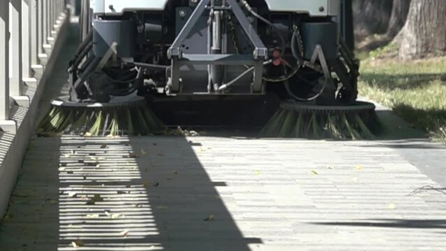 A special car (street-sweeping machine) sweeps the streets with a special brush. Super slow motion 1000 fps