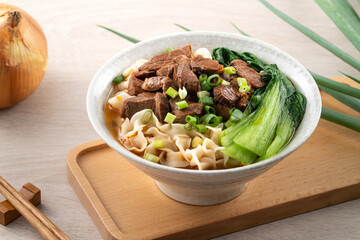 Beef noodle soup. Taiwanese famous food in a bowl on wooden table.