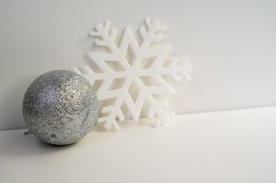 silver Christmas ornaments with white snow flake in white background