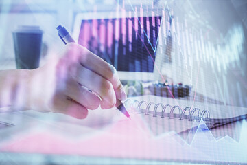 Financial forex graph drawn over hands taking notes background. Concept of research. Multi exposure