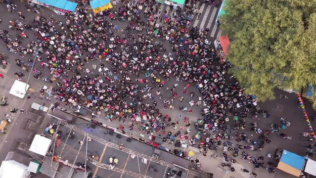 Aerial straight down shot of celebrating people on street in Buenos Aires - Feria de Mataderos with stage dancing Chacarera 