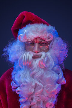Studio shot of elderly santa claus dressed in red clothes and hat.