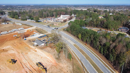 Local church near large construction project with heavy machine, cement pipes, debris pile and...