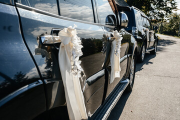 The wedding black car is decorated with white flowers, white flowers are a symbol of innocence on...