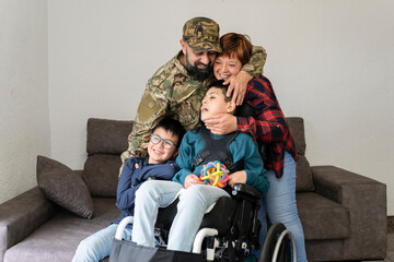 Fototapeta na wymiar Latin Family of four with military soldier father and disabled child in wheelchair. Dad arrives from war. Unconditional love concept