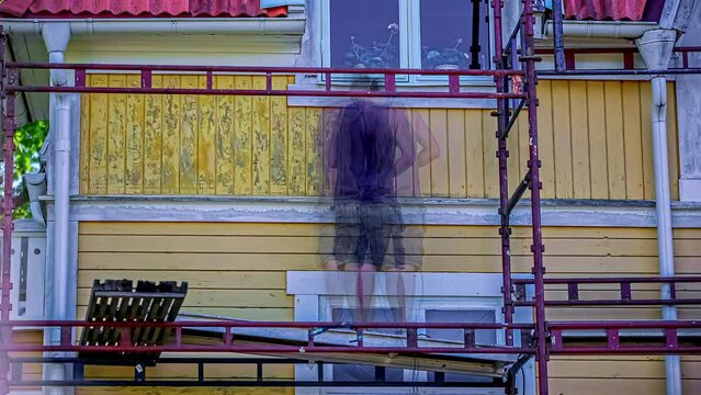 Man Applying Chemical Paint Remover On House Exterior Wall. timelapse