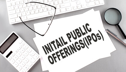 Initial Public Offering text on paper with keyboard, calculator on grey background