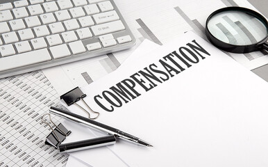 COMPENSATION text on paper with chart and keyboard, business concept