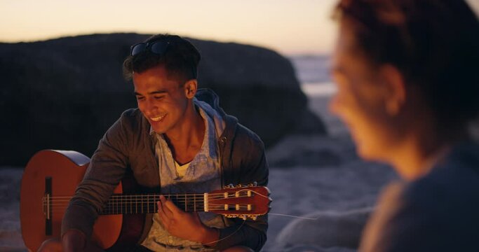 Sunset, bonfire and friends at beach with guitar, having fun and relaxing. Campfire, gen z and group of people outdoors talking, bonding and enjoying time together with acoustic string instrument.