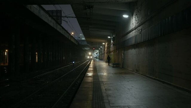 Abandoned railway / subway platform. Ghetto. Rainy autumn foggy weather in the night city. Gotham city mood. Cinematic style. Dungeon columns and dim light. Graffiti on the walls. One woman walks alon