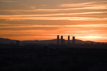 Madrid city skyline in silhouette sun and mountains on background five towers bussiness area skycrapers