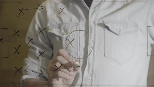 Soccer manager drawing game strategy plan on glass