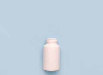 White plastic medicine bottle on blue background