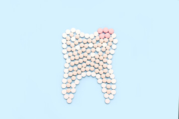 Shape form tooth with cariesmade of pills. Dental clinic concept.