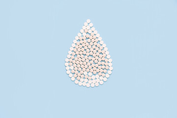 Drop of blood made  pills on blue background..Concept of give blood donation, blood transfusion. World hemophilia day.