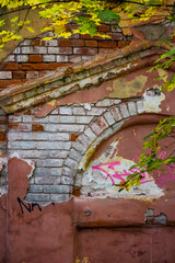 Peeling plaster on the facade of an old brick building, vertical background
