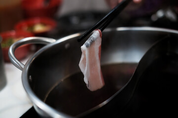 chopsticks with bacon pork and ingredients background for Japanese shabu-shabu or Sukiyaki, selective focus.