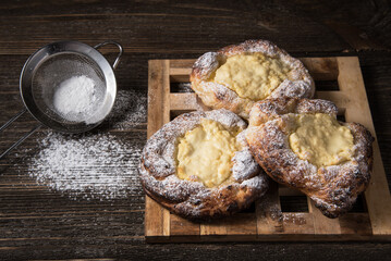 Patties with cottage cheese on a wooden table. Russian pastry (vatrushka)