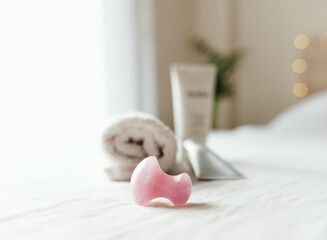 Rose quartz mushroom stone for facial massage on white surface